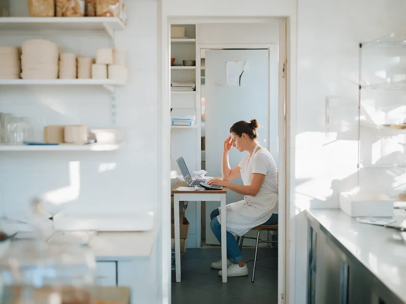 Door de deuropening van een bakkerij: de eigenaar zit na sluitingstijd in het kantoortje met een laptop en een stapel facturen.
